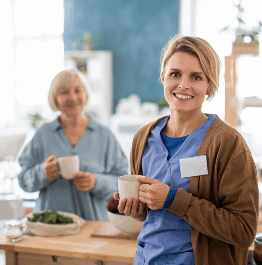 Healthcare worker and elderly woman with mugs.